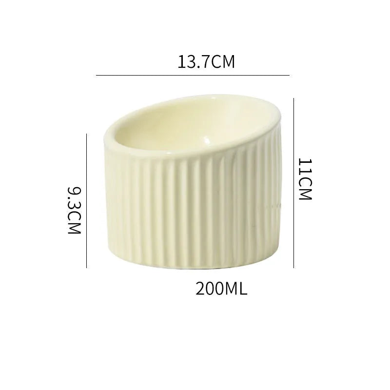 Ceramic raised cat bowl in light green, showing elevated tilted design for pet feeding.