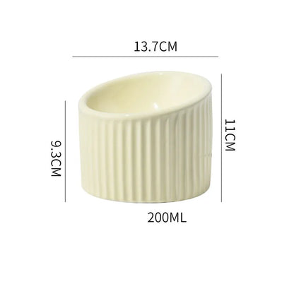 Ceramic raised cat bowl in light green, showing elevated tilted design for pet feeding.