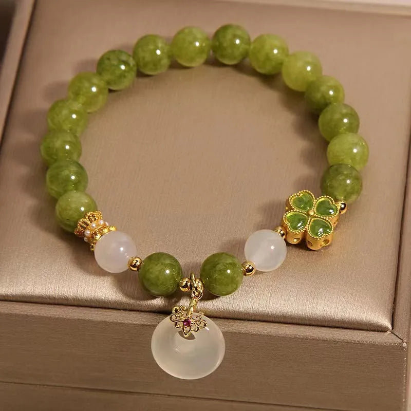 Green tourmaline women's bracelet with four-leaf clover safety buckle and geometric drop shape.