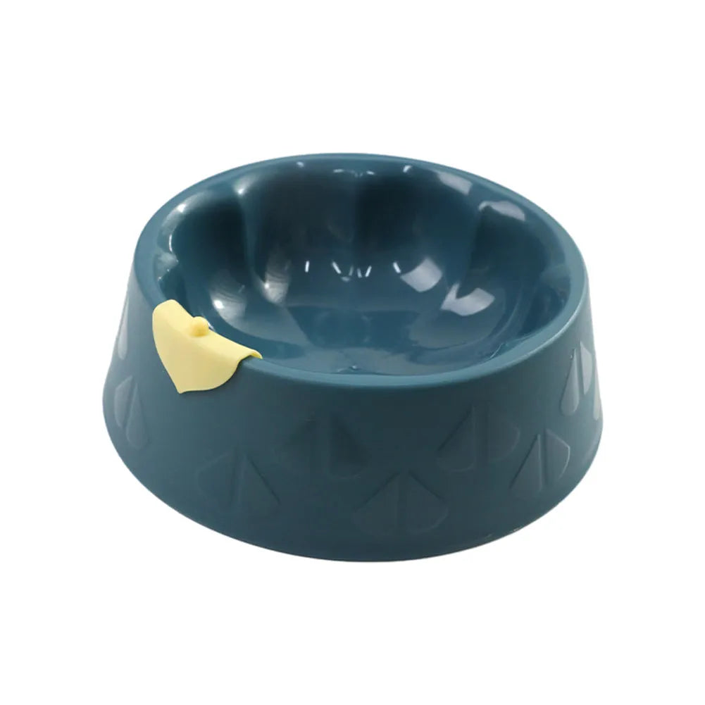 Green plastic double pet bowl with two compartments for food and water on a flat surface.