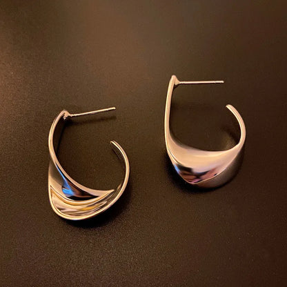 Gold twisted geometric metal earrings with circular elements and electroplated finish