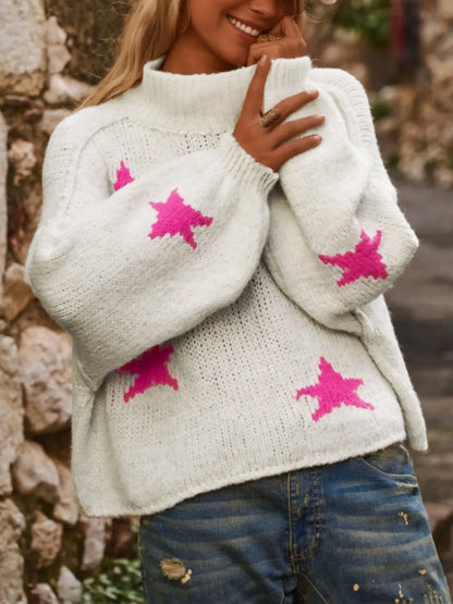 White women's turtleneck pullover with a black star pattern, loose fit, and long sleeves.