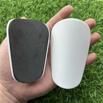 Extra small plastic football shin guards in black and white colours for youth players