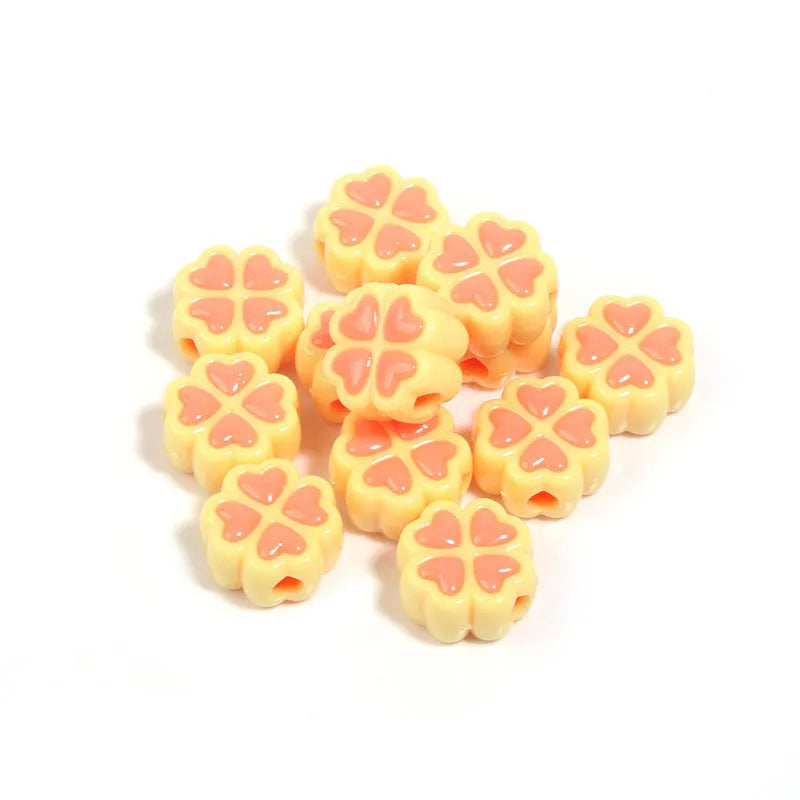 Assorted frosted acrylic four-leaf clover shaped beads in pink, green, and yellow, 15mm diameter.