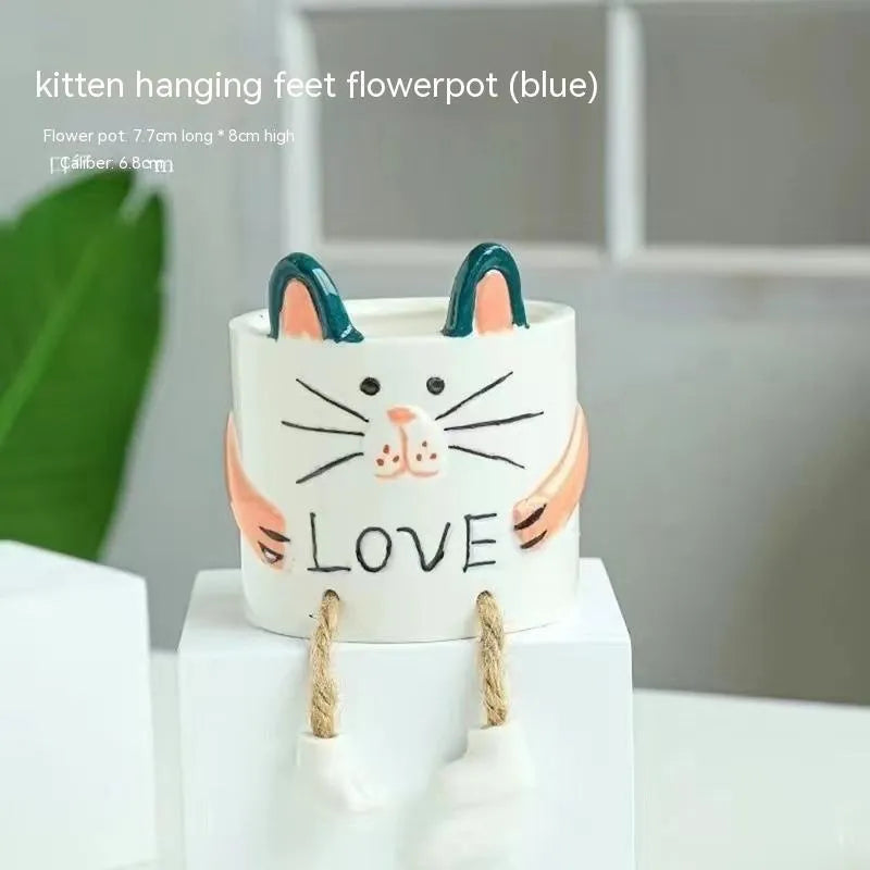 Ceramic hanging foot flowerpot for succulent plants with cartoon styling on desktop