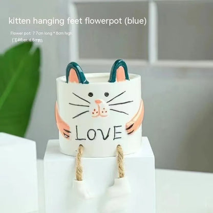Ceramic hanging foot flowerpot for succulent plants with cartoon styling on desktop