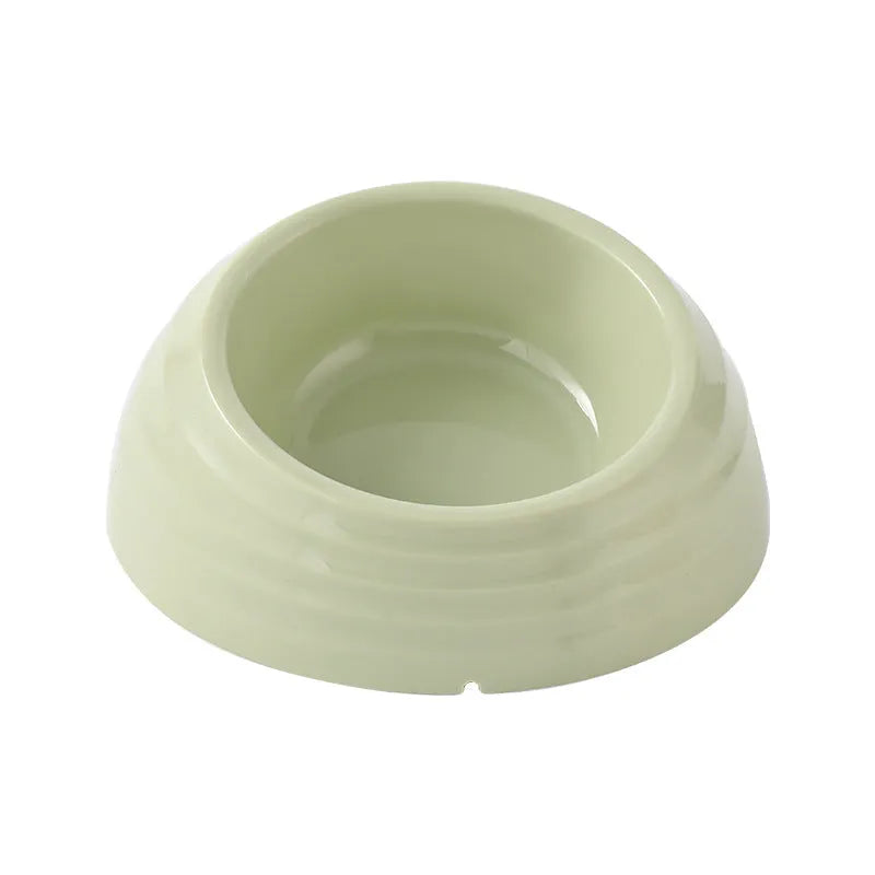 Single stainless steel cat bowl with a light green plastic base on a floor.