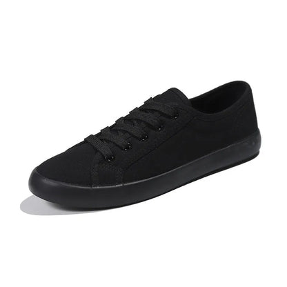 All-black women's canvas work shoes with flat rubber soles and lace-up front