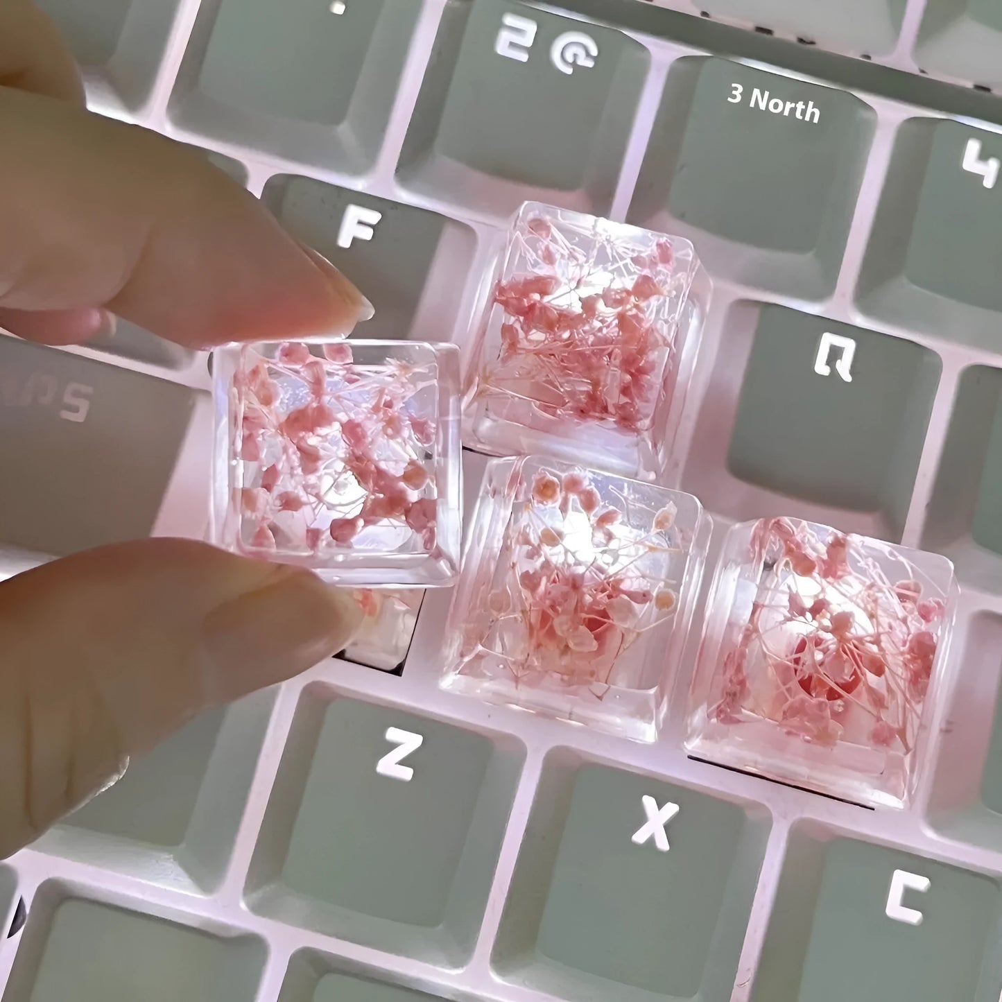 A transparent resin keycap with a starry sky design inside, shown in a green colour variant.