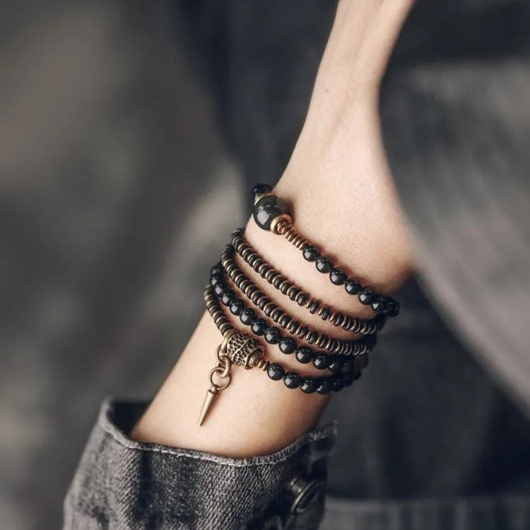 Black geometric layered beaded bracelet shown on a wrist.