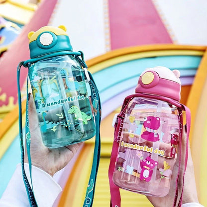 Red children's water cup with shoulder strap showing cartoon pattern and suction nozzle