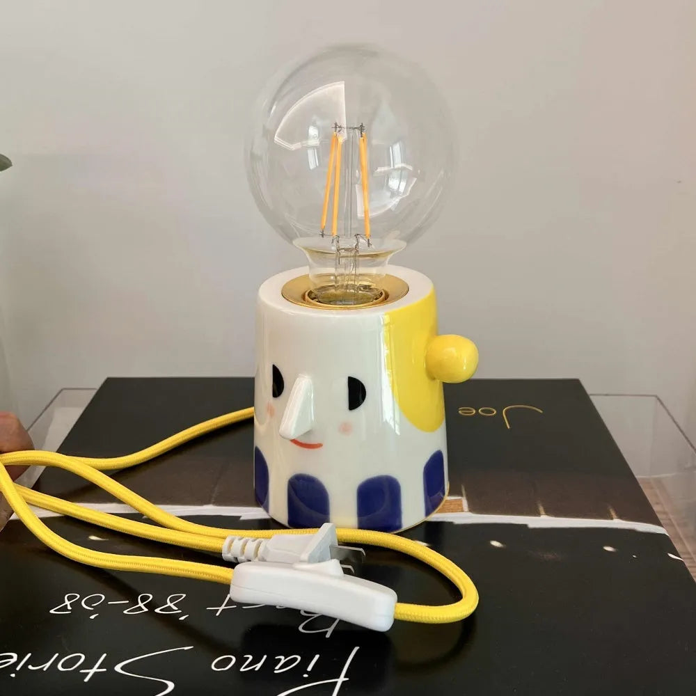 Handmade ceramic lamp with ball headlight design on a bedside table