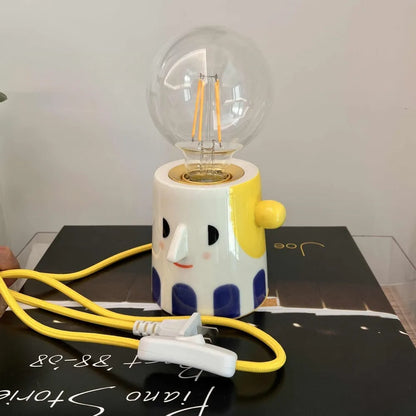 Handmade ceramic lamp with ball headlight design on a bedside table