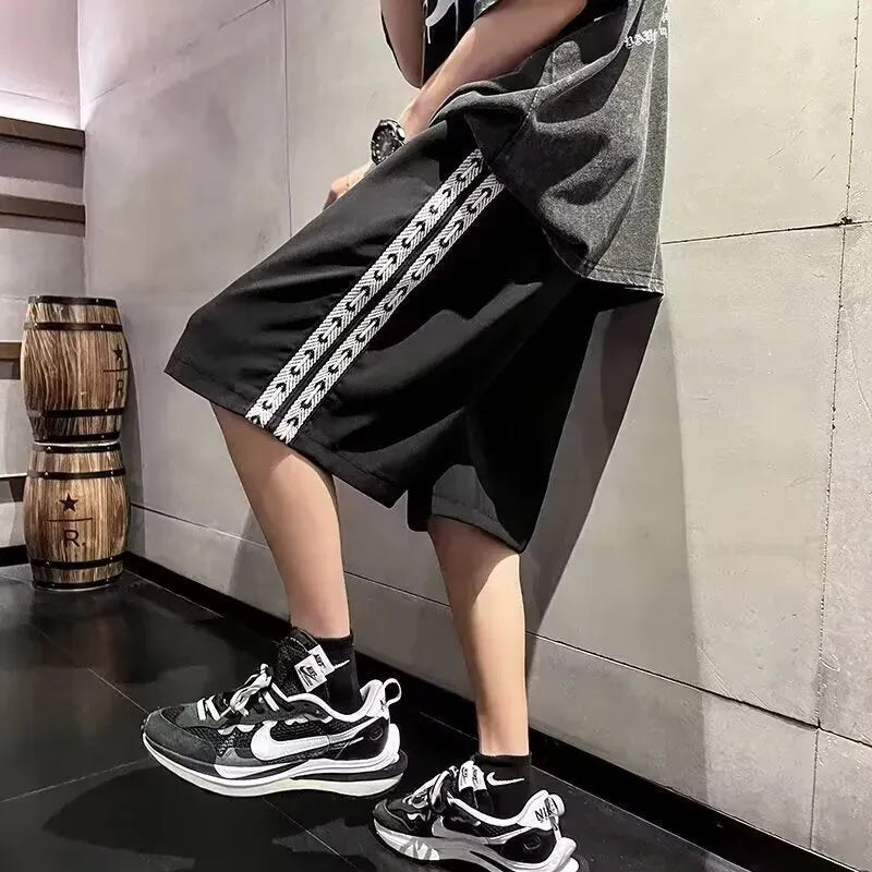Man wearing loose-fit black baggy track pants with an elasticated waist for casual athletic wear