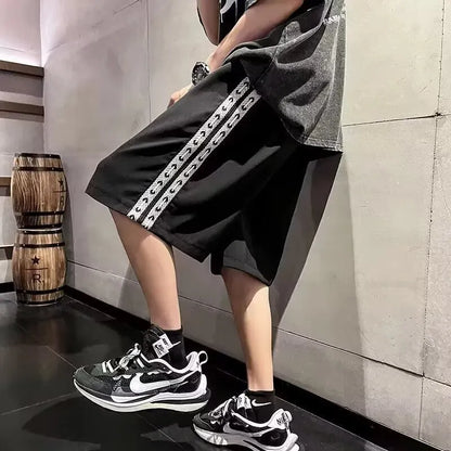 Man wearing loose-fit black baggy track pants with an elasticated waist for casual athletic wear