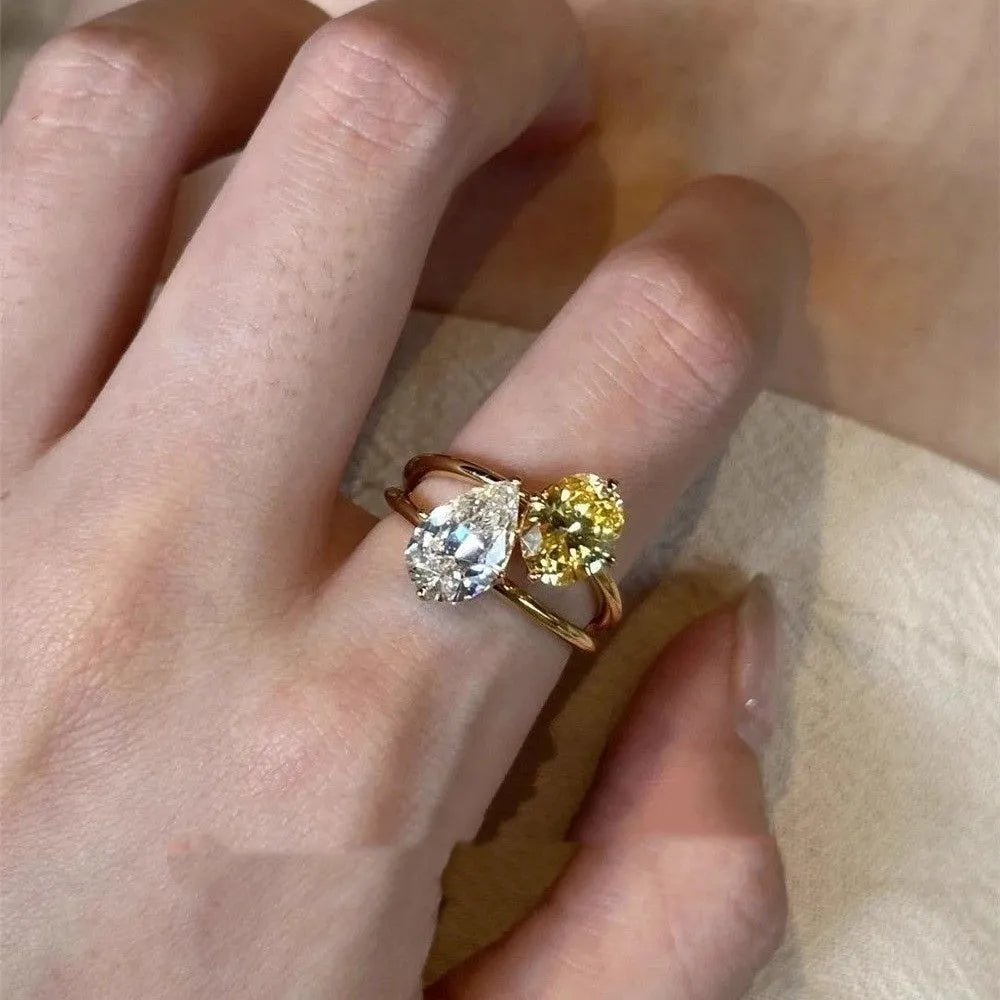 Geometric open ring with water drop shaped zircon stones on copper band, adjustable design for women's fashion