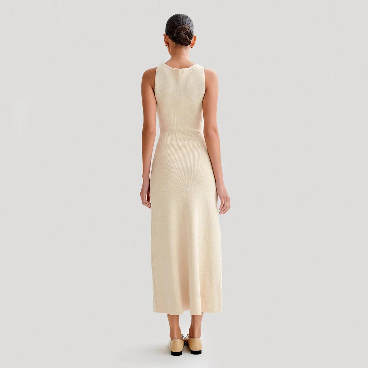 Elegant sleeveless knit dress in various colors, including almond and blue, with a slim, figure-flattering silhouette and round neckline