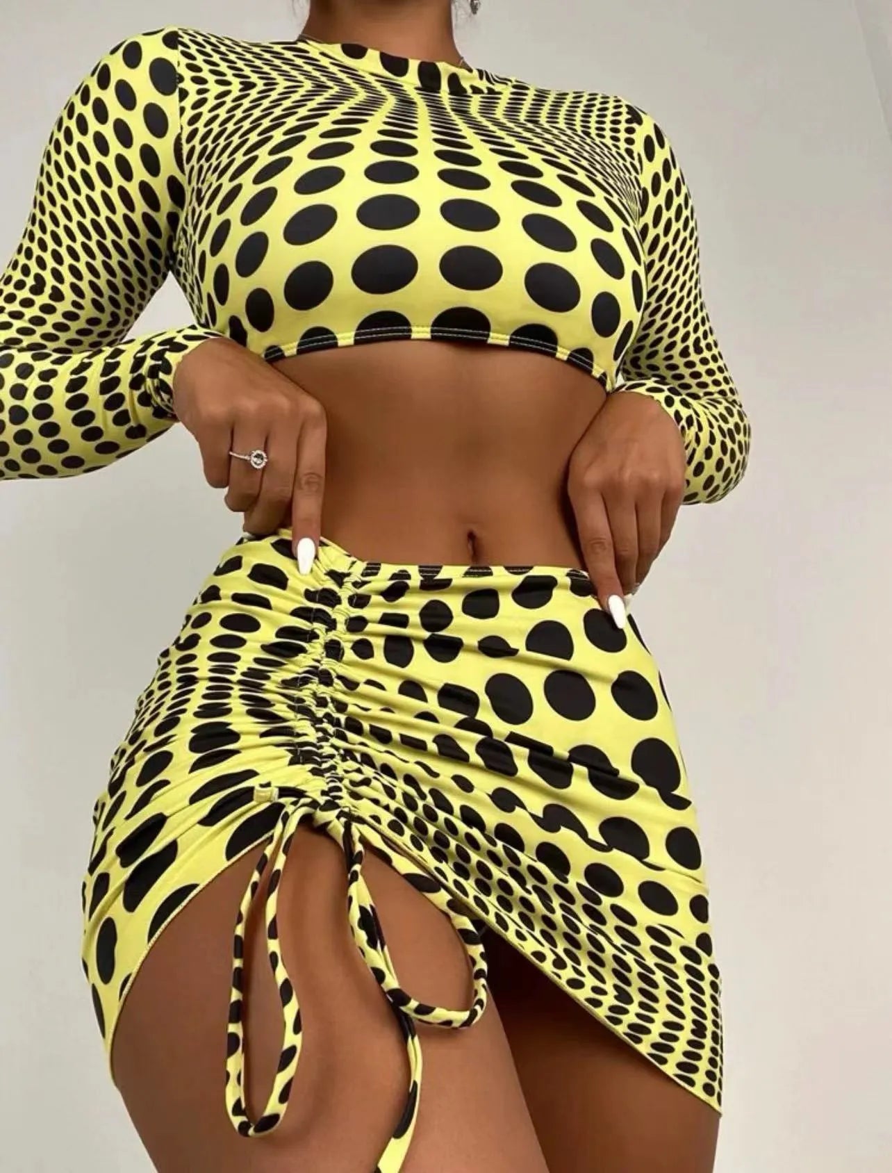 Green polka dot women's three-piece swimsuit set with top, skirt, and bra on hanger