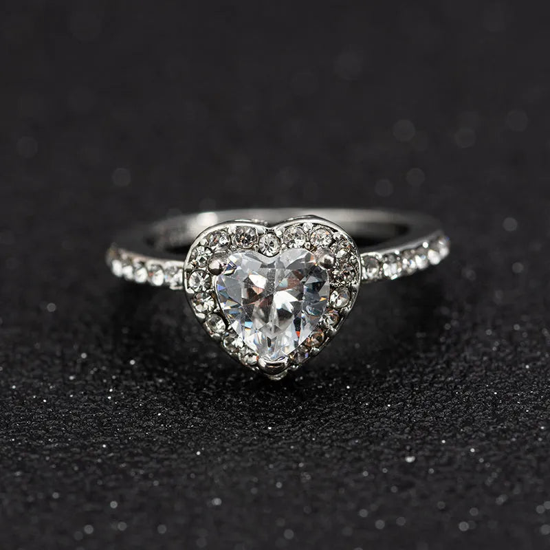 Women's heart-shaped crystal wedding ring in rose gold or silvery on a white background.