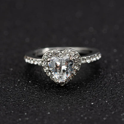 Women's heart-shaped crystal wedding ring in rose gold or silvery on a white background.