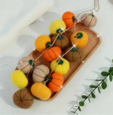 Wool felt pumpkin ornaments in various colours for doll decoration and craft projects.