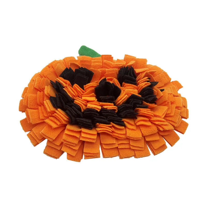 Orange pumpkin-shaped fleece pet slow feeder mat for dogs and cats on a wooden floor