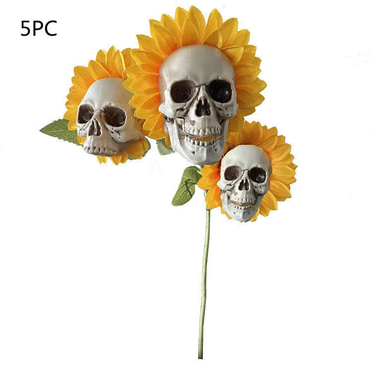 A group of skull-shaped sunflower ornaments arranged in a Halloween-themed outdoor display