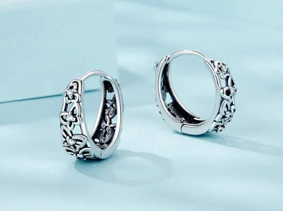 Sterling silver retro hollow butterfly earrings with zircon stones on a white background.