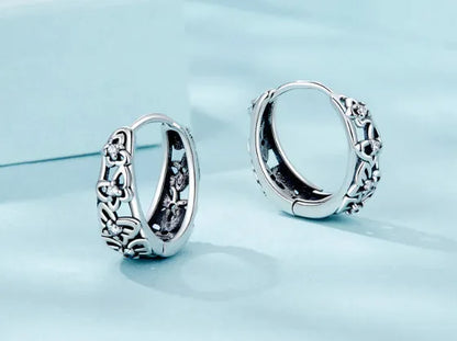Sterling silver retro hollow butterfly earrings with zircon stones on a white background.