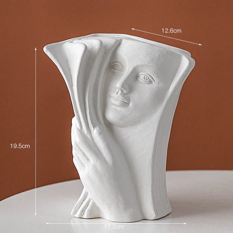 White ceramic book stand holding an open book at an angle, with a wire page holder in use.
