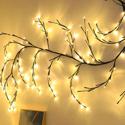 Flexible DIY willow vine LED light garland with warm white lights shaped on a wall.