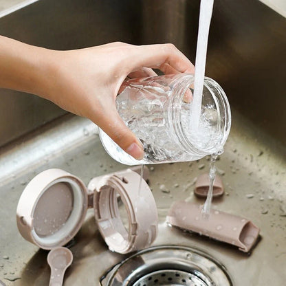 Small glass seasoning jars with lids and spoons in various colors for kitchen organization