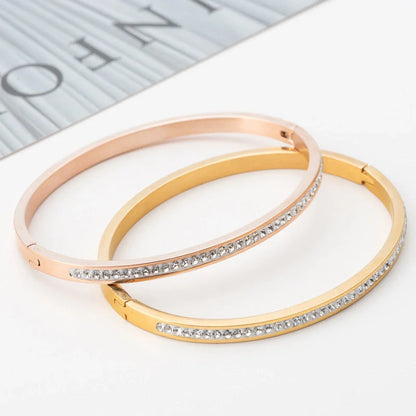 Elegant stainless steel bracelet with diamond accent, available in gold, rose gold, and steel finishes.