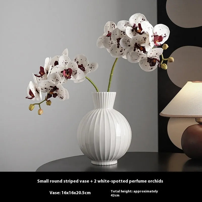 White ceramic ball-shaped vase with striped pattern, shown in small and large sizes with orchid arrangements