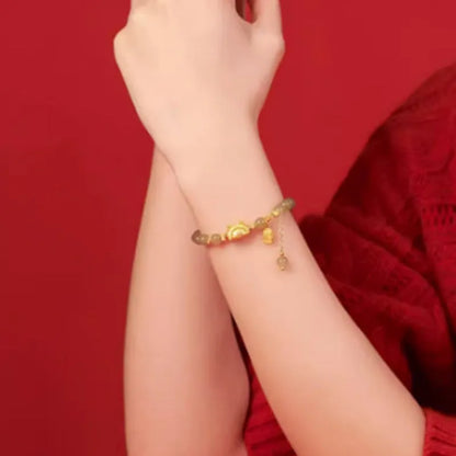 Women's Chinese style bracelet with Hetian jade, red agate beads, and a dragon design on gold and silver.