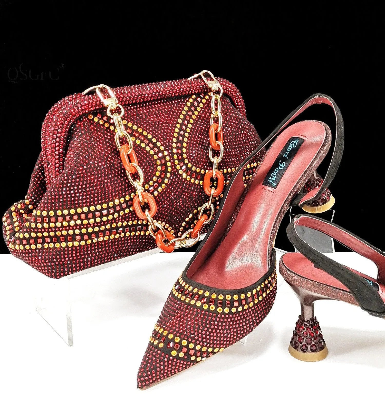 Women's pointed toe high heel court shoes in blue with rhinestone detail and a matching small bag.