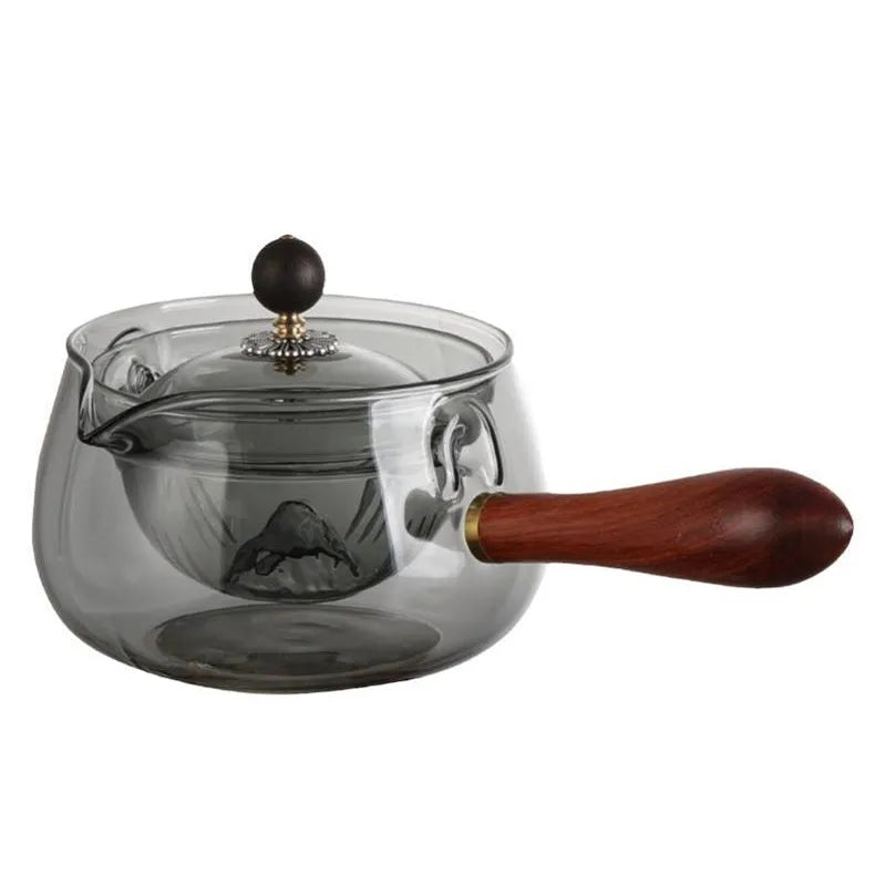 Glass teapot with wooden handle showing transparent borosilicate construction and removable infuser