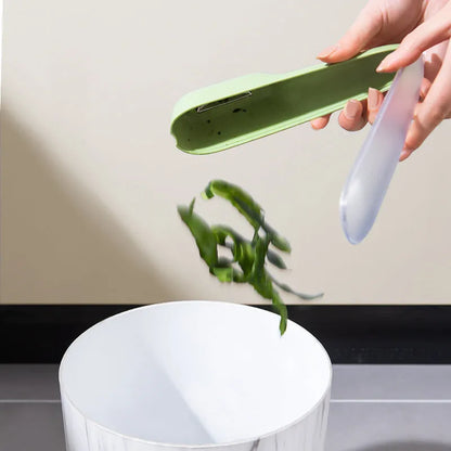 Dark green kitchen peeler with stainless steel blade and storage tube, measuring 20cm by 4.8cm, on a countertop