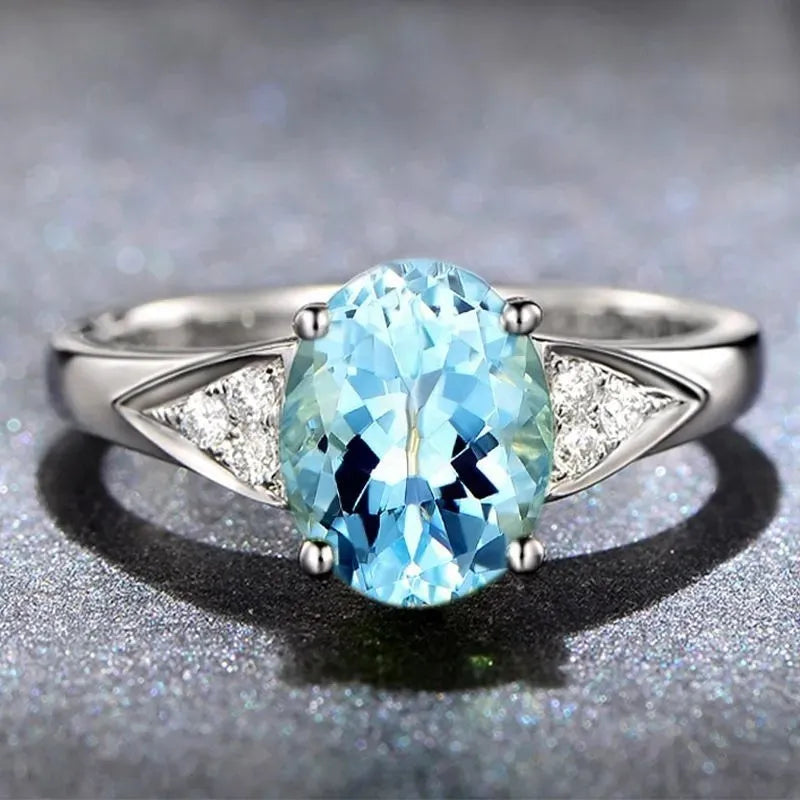 Women's zircon ring with natural blue or red zircon inlay, showing heart, water drop, or bell pattern on court style band.