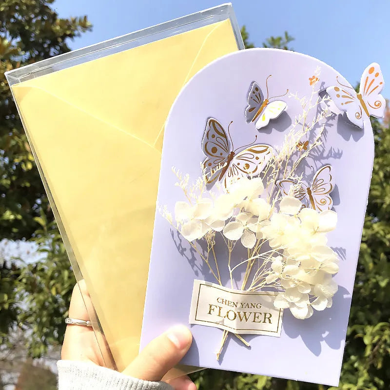 Handmade 3D pop-up greeting card with butterfly shape showing artificial flowers and hot stamping details