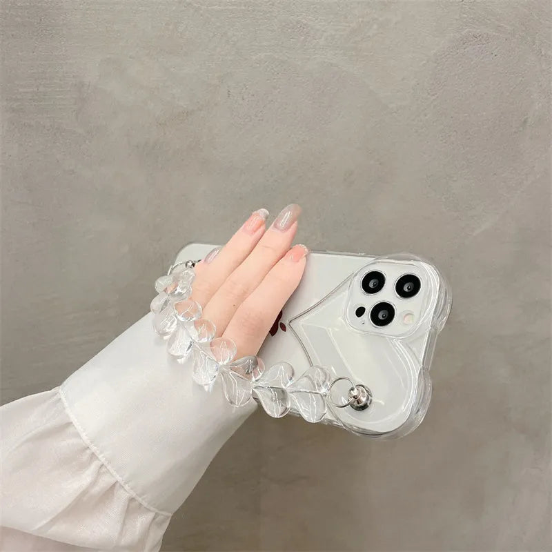 Transparent TPU iPhone case with love bracelet and heart chain design on a table.