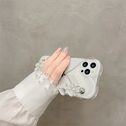 Transparent TPU iPhone case with love bracelet and heart chain design on a table.