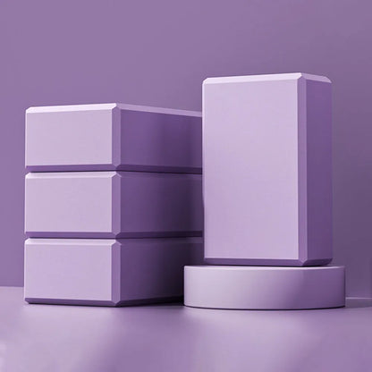 Blue EVA foam yoga block on a yoga mat, showing 23x15x7.6cm dimensions and textured surface for grip
