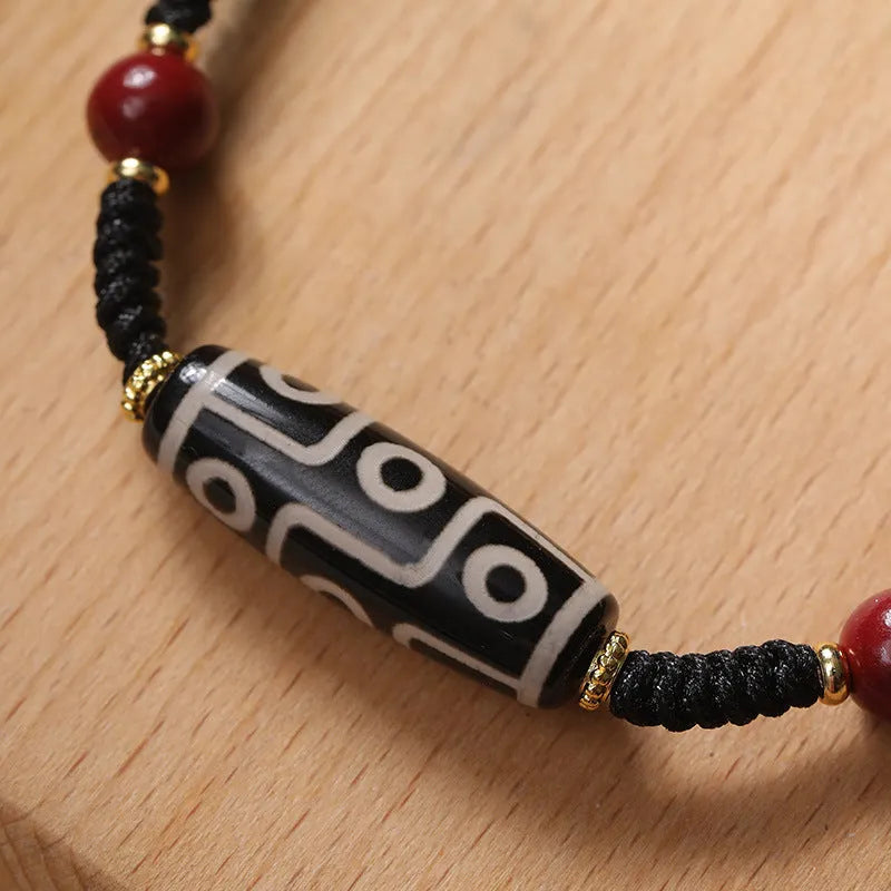 Men's adjustable agate dzi bead bracelet with traditional symbols on a shrinkable band.