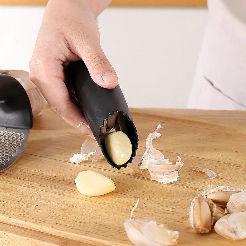 Stainless steel garlic press with coloured handles in a modern design, shown on a kitchen counter.