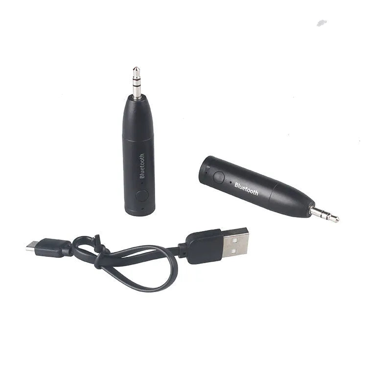 Compact black Bluetooth audio receiver with 3.5mm jack for car stereo and USB cable.