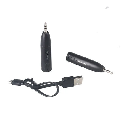 Compact black Bluetooth audio receiver with 3.5mm jack for car stereo and USB cable.