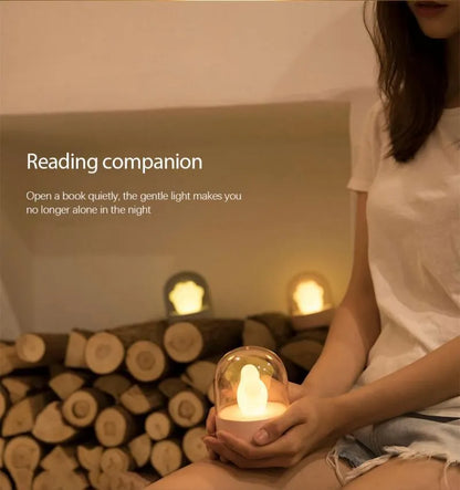 Grey cat paw shaped night light with USB port, shown on a wooden desk next to a charging cable.