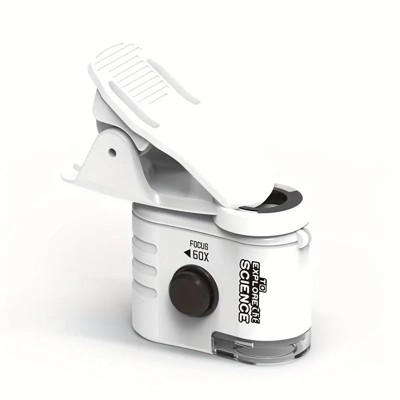 White mini mobile phone microscope with LED light and detachable clip-on adapter next to a smartphone.