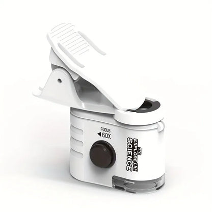 White mini mobile phone microscope with LED light and detachable clip-on adapter next to a smartphone.